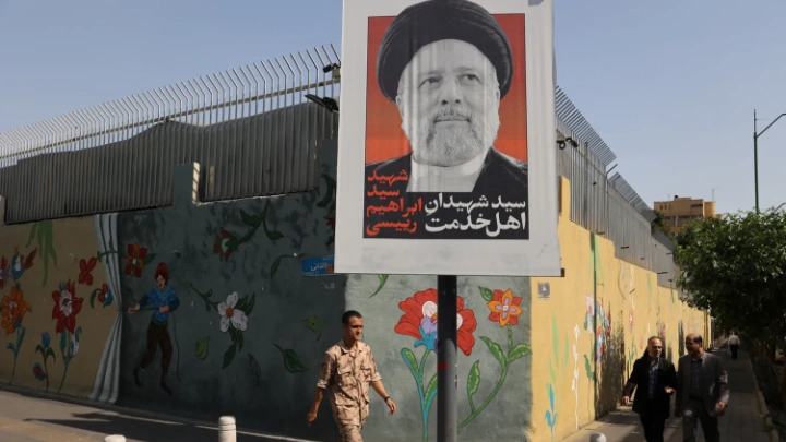 A person walks past a banner with a picture of Iran's late president, Ebrahim Raisi, on a street in Tehran, Iran, May 20, 2024. Majid Asgaripour/WANA (West Asia News Agency) via REUTERS