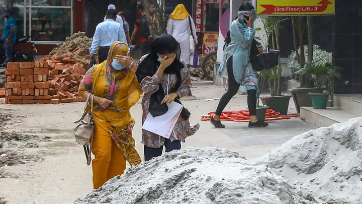 Three women cover their faces with scurf as they try to protect themselves after the wind blows away sands that were kept on the road, as construction work is underway next to it. The picture was taken from Chowdhurypara of Khilgaon, Dhaka on 11 August 2022.Dipu Malakar.