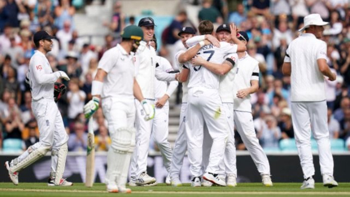 England's Ollie Robinson is embraced by captain Ben Stokes after taking the wicket of South Africa's Dean Elgar on day three of the third LV= Insurance Test match at the Kia Oval, London, Saturday Sept. 10, 2022. (John Walton/PA via AP)