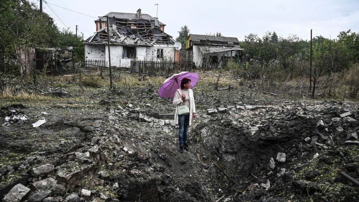 A woman stands in front of a destroyed house, in Kramatorsk, Donetsk region, on September 12, 2022 Juan BARRETO AFP