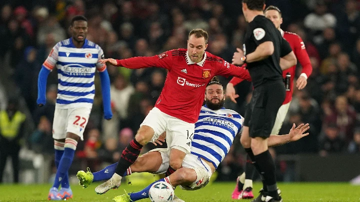 Manchester United's Christian Eriksen is tackled from behind by Reading's Andy Carroll during their FA Cup fourth round tie in Manchester Saturday