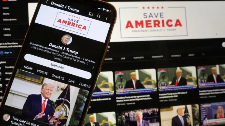 Former U.S. President Donald Trump's YouTube account is seen on a mobile phone and laptop computer after being restored by Google and its parent company Alphabet Inc, as Google lifted a more than two-year suspension imposed on Trump after the deadly January 6, 2021 Capitol Hill riot, in Washington, U.S. March 17, 2023. REUTERS/Jim Bourg