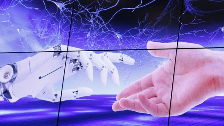 An illustration projected on a screen shows a robot hand and a human one moving towards each others during the "AI for Good" Global Summit at the International Telecommunication Union (ITU) in Geneva, Switzerland, June 7, 2017. REUTERS/Denis Balibouse