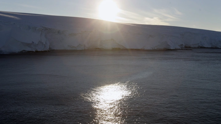 The sun sets behind the coastline at Cape Denison, Commonwealth Bay, East Antarctica January 2, 2010. Photo :Reuters