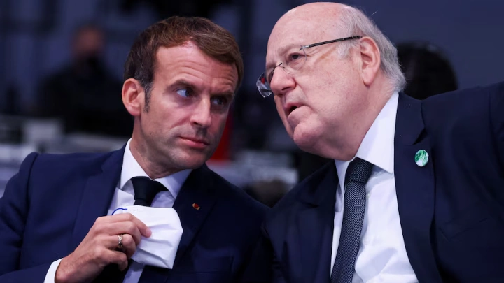 Lebanese Prime Minister Najib Mikati speaks with French President Emmanuel Macron, as they attend the UN Climate Change Conference (COP26) in Glasgow, Scotland, Britain, November 1, 2021. REUTERS/Yves Herman/Pool/File Photo 