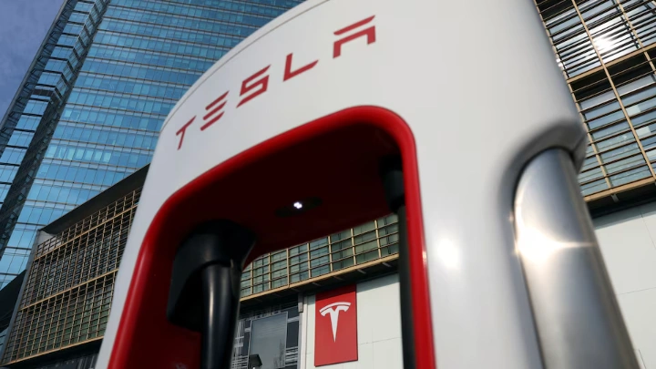 The Tesla logo is seen through a charging station outside a store of the electric vehicle (EV) maker in Beijing, China January 4, 2024. REUTERS/Florence Lo/File photo