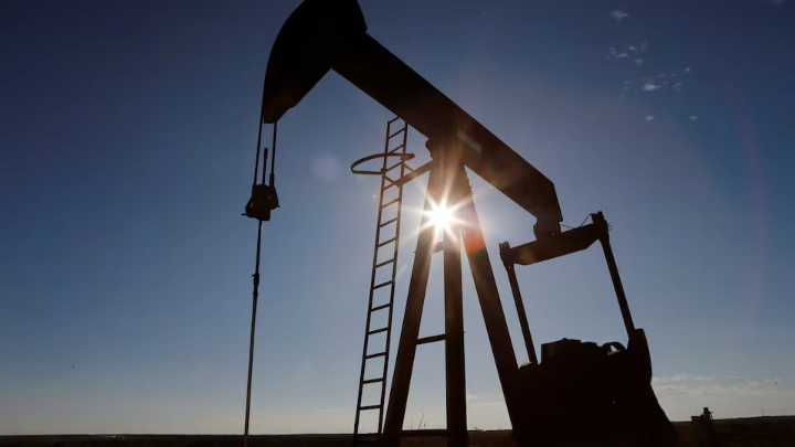 The sun is seen behind a crude oil pump jack in the Permian Basin in Loving County, Texas, U.S., November 22, 2019. REUTERS/Angus Mordant/File Photo